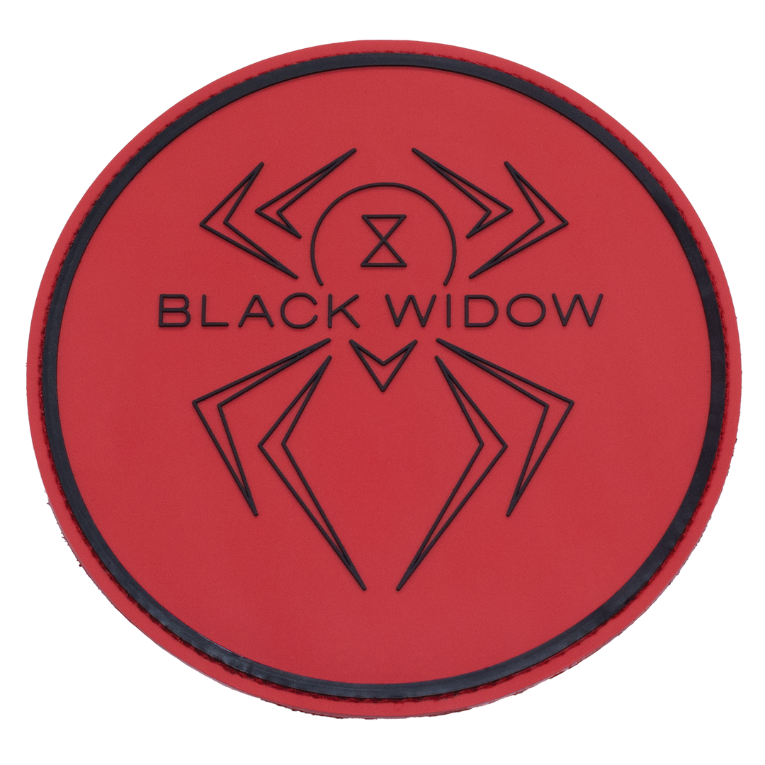 A round shammy pad with a red, rubber front with the Black Widow logo and a thicker line near the edge of the circle shape molded in black into the rubber.