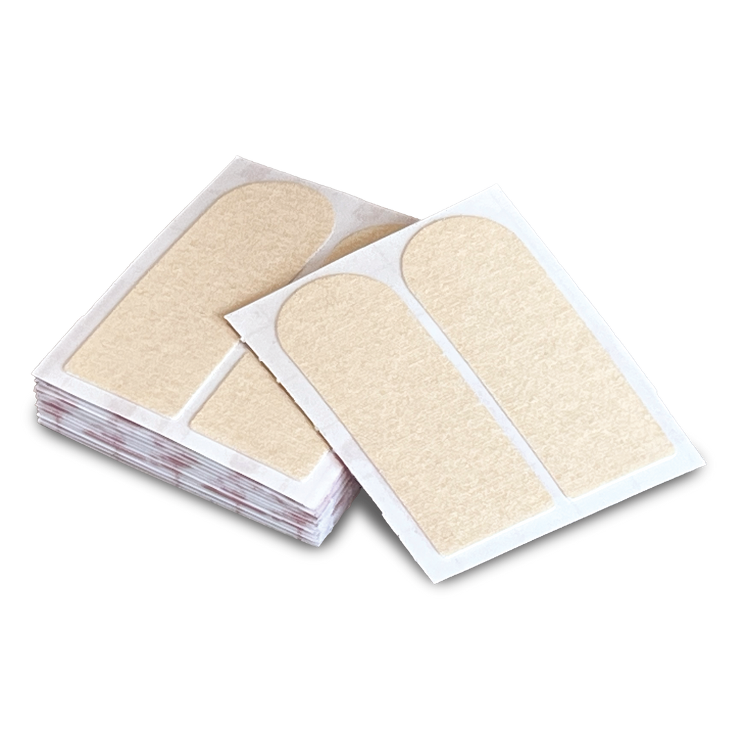 A stack of multiple sheets of Insert Tape two per sheet cream colored.