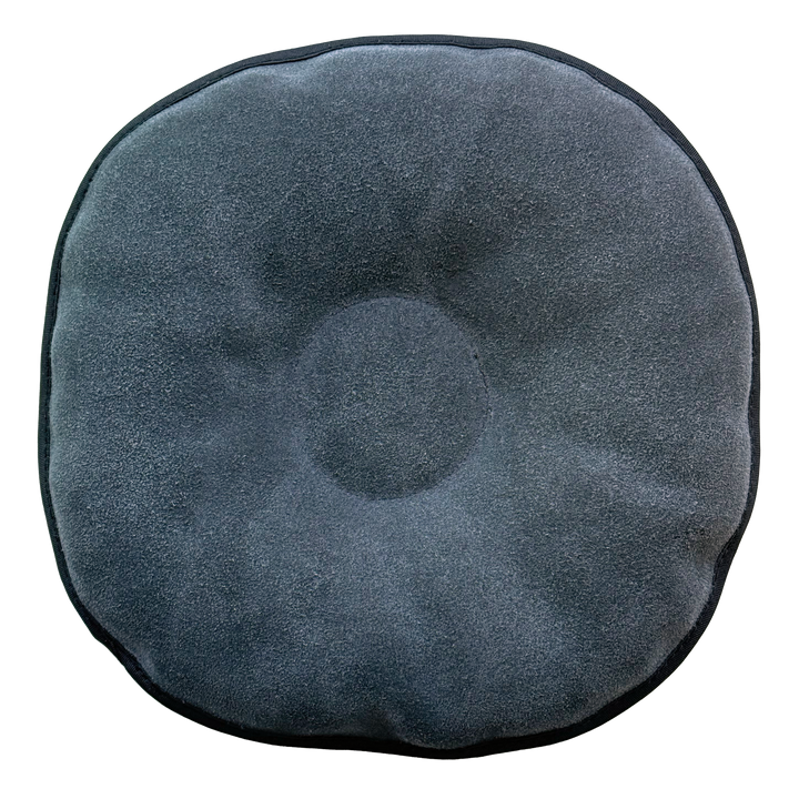 The back side of a round pillow-like shammy pad with a solid grey background.