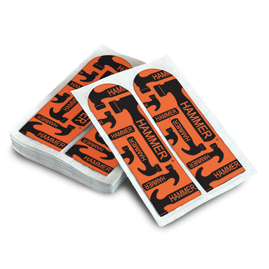 A stack of multiple sheets of Pre-Cut Skin Protection Tape with black Hammer logos printed on an orange material.