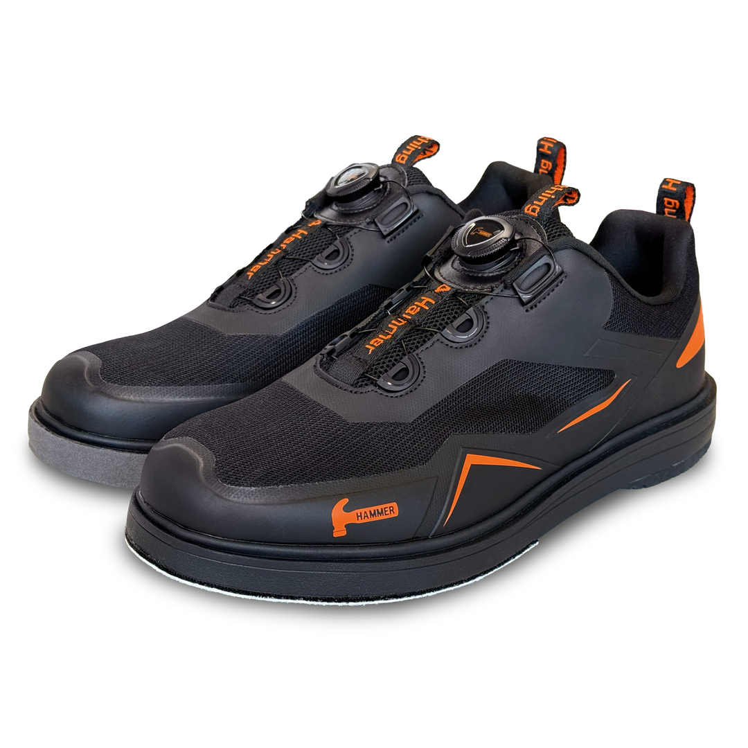 A black pair of shoes with orange accents in a three-quarter view facing left.