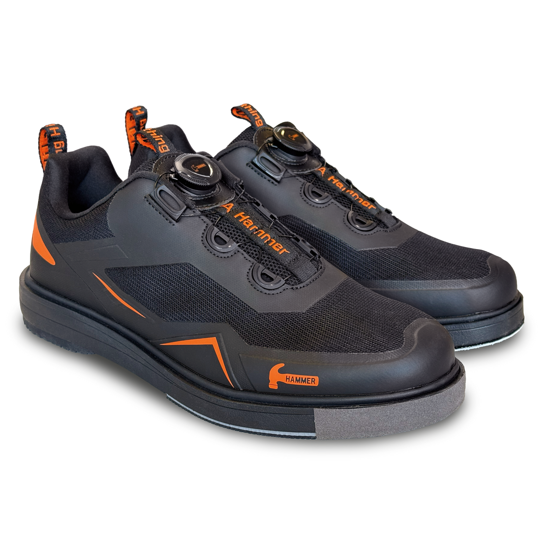 A black pair of shoes with orange accents in a three-quarter view facing right.